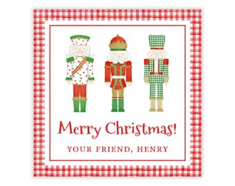 Può includere: Un biglietto di Natale quadrato con un bordo a quadretti rosso e bianco. La carta presenta tre schiaccianoci illustrati in abiti festivi. Le parole "Merry Christmas!" sono scritte in rosso, con "YOUR FRIEND, HENRY" sotto.