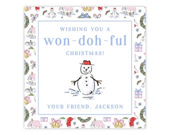 Può includere: Biglietto di Natale quadrato con bordo blu e illustrazione di pupazzo di neve con cappello rosso. Il biglietto recita "Wishing you a won-doh-ful Christmas!" e "Your friend, Jackson."