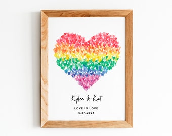 May include: A framed print with a rainbow heart made of small hearts. The text below the heart reads "Kyler & Kat, Love is Love, 6.27.2021".