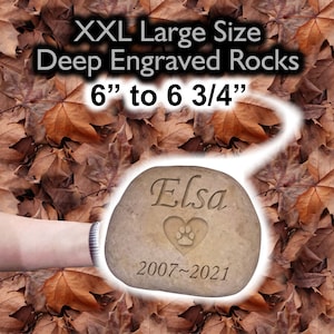 May include: A large, light brown, engraved pet memorial rock with the name "Elsa" and the dates "2007-2021". The rock is 6 to 6 3/4 inches in size.