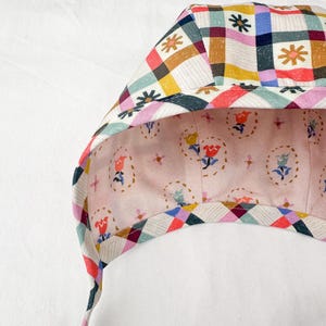 Interior view of the bonnet showing the gingham floral side with clear details of the multicoloured checkered pattern and floral motifs.