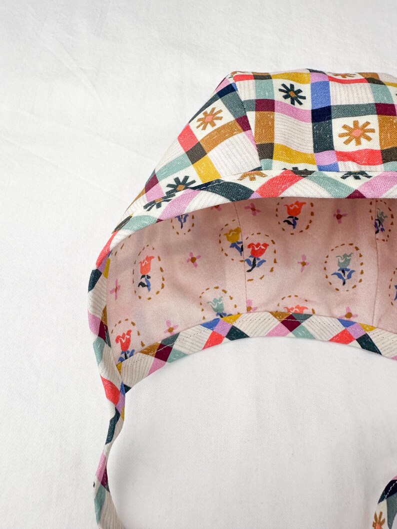 Interior view of the bonnet showing the gingham floral side with clear details of the multicoloured checkered pattern and floral motifs.