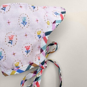 Floral side of reversible baby bonnet with chin ties, handmade organic cotton spring bonnet