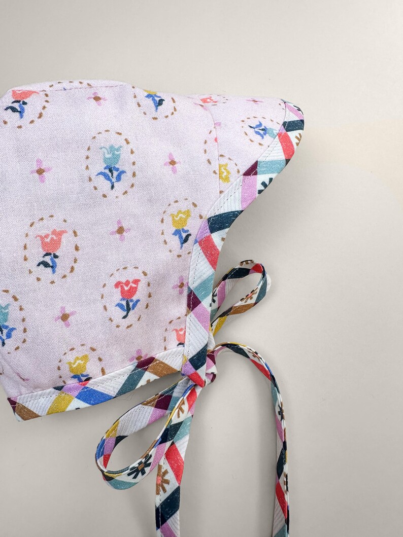 Floral side of reversible baby bonnet with chin ties, handmade organic cotton spring bonnet