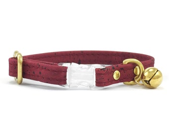 Peut inclure: Un collier pour chat de couleur bordeaux avec une boucle en plastique transparente et une clochette dorée. Le collier est en liège.