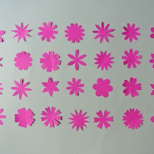 May include: Thirty-six pink paper flowers of various sizes and shapes, arranged in four rows of nine flowers each.