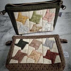 May include: Two quilted zippered pouches with a patchwork design. The top pouch is green with a beige background and the bottom pouch is brown with a beige background. Both pouches feature a pattern of colourful fabric squares sewn together in a pinwheel design.