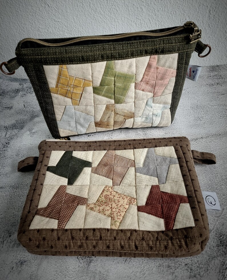 May include: Two quilted zippered pouches with a patchwork design. The top pouch is green with a beige background and the bottom pouch is brown with a beige background. Both pouches feature a pattern of colourful fabric squares sewn together in a pinwheel design.