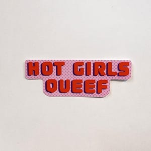 May include: A rectangular sticker with a light pink background featuring a darker pink polka dot pattern. The text HOT GIRLS QUEEF is printed in bold, blocky red letters with a dark purple drop shadow, arranged in two lines on the sticker.