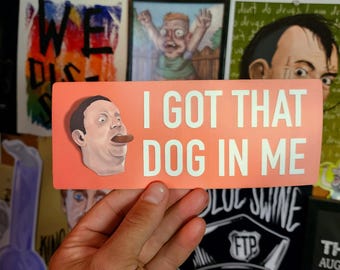 May include: A pink and white sticker with the text "I got that dog in me" in white letters. A cartoon man with a mustache is holding a cigar in his mouth.