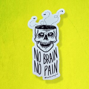 May include: A white sticker with a black and white illustration of a skull with its brain removed. The sticker says "No Brain No Pain" and is signed "@ThatScumbagJim".