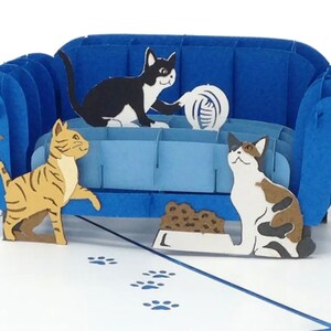 Cat Trouble pop up card: 3 playful cats cavort by a blue couch. They are ready to create mischief.