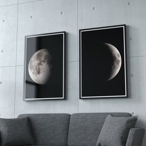 May include: Two black framed prints of the moon in different phases. The print on the left shows a full moon, while the print on the right shows a crescent moon. Both prints are on a black background.