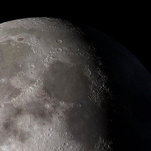 May include: A close-up view of the moon's surface, showing craters and other geological features. The moon is a celestial body that orbits the Earth.