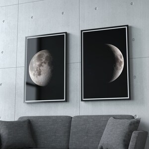 May include: Two black framed prints of the moon in different phases. The print on the left shows a full moon, while the print on the right shows a crescent moon. Both prints are on a black background.