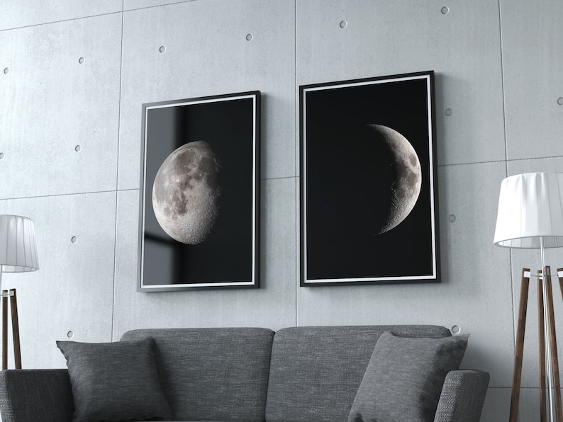 May include: Two black framed prints of the moon in different phases. The print on the left shows a full moon, while the print on the right shows a crescent moon. Both prints are on a black background.