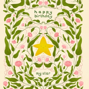 Pu&ograve; includere: Biglietto di compleanno con una stella gialla e le parole "happy birthday my star". Il biglietto presenta un design floreale con foglie verdi e fiori rosa, il tutto su uno sfondo color crema.