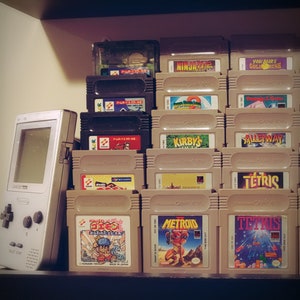 May include: A collection of vintage Game Boy cartridges, including titles like "Ninja Gaiden", "Yogi Bear's Gold Rush", "Tetris", "Metroid", and "Kirby's Dream Land".
