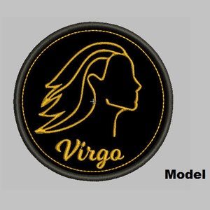 May include: Black and gold embroidered patch with the astrological sign Virgo. The sign is a stylized outline of a woman's head and shoulders with flowing hair.