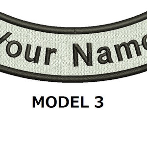 May include: Black and white embroidered patch with the text "Your Name" on a white background. The patch is curved and has a black border. Model 3.