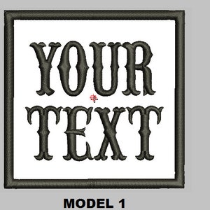 Puede incluir: Un parche cuadrado blanco con un borde negro y el texto "YOUR TEXT" en una fuente decorativa.