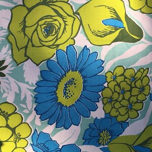 May include: A floral fabric with a white background and a variety of colorful flowers. The flowers include yellow roses, blue daisies, and green and yellow flowers.