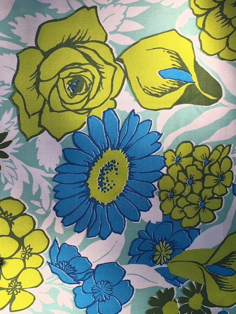 May include: A floral fabric with a white background and a variety of colorful flowers. The flowers include yellow roses, blue daisies, and green and yellow flowers.