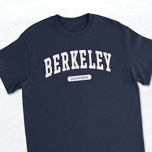 Könnte beinhalten: Ein marineblaues T-Shirt mit weißem Text, der "BERKELEY KALIFORNIEN" lautet.