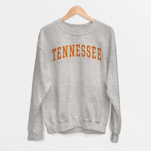 May include: A gray sweatshirt with the word "TENNESSEE" printed in orange on the front.