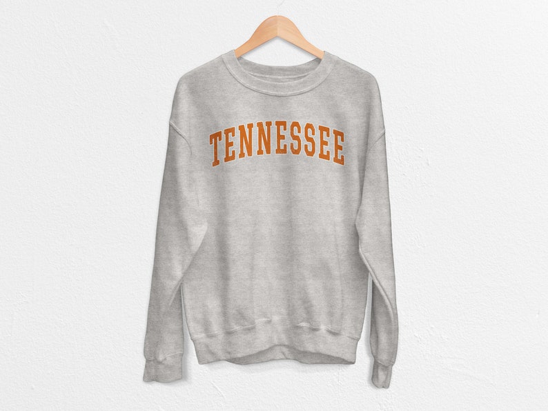 May include: A gray sweatshirt with the word "TENNESSEE" printed in orange on the front.