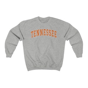 May include: A gray sweatshirt with the word "TENNESSEE" printed in orange on the front.
