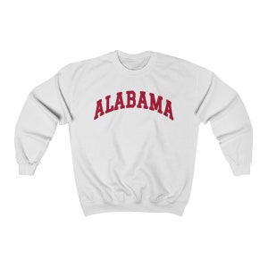 K&ouml;nnte beinhalten: Wei&szlig;er Pullover mit einem roten Bogen-Design, auf dem "ALABAMA" steht.