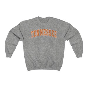 May include: A gray sweatshirt with the word "TENNESSEE" printed in orange on the front.