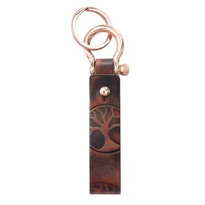 May include: A brown leather keychain with a tree design and a gold metal key ring.