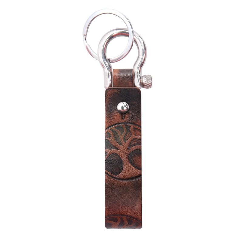 May include: A brown leather keychain with a tree design and a silver metal key ring.