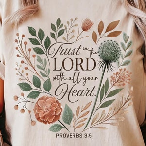 May include: A beige t-shirt with a floral design and the text "Trust in the LORD with all your Heart. Proverbs 3:5"