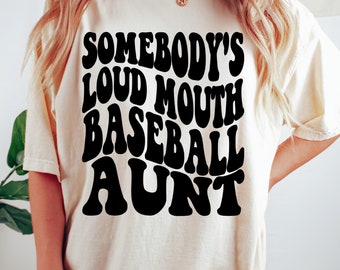 May include: A white t-shirt with black text that reads "Somebody's Loud Mouth Baseball Aunt" in a retro font.