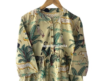 May include: A beige cotton dress with a jungle print featuring toucans, zebras, leopards, and palm trees. The dress has a button-up front and a drawstring waist.