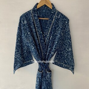 May include: A blue cotton robe with a white sea creature print and cream trim. The robe has a tie belt and two pockets.