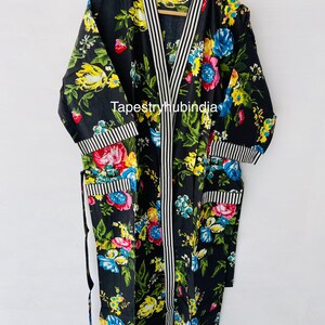 May include: Black floral print cotton robe with white and black striped trim. The robe has a long sleeve and a tie closure. The text "Tapestryhubindia" is visible on the robe.