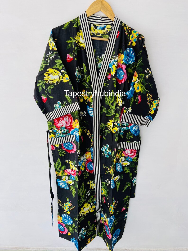 May include: Black floral print cotton robe with white and black striped trim. The robe has a long sleeve and a tie closure. The text "Tapestryhubindia" is visible on the robe.