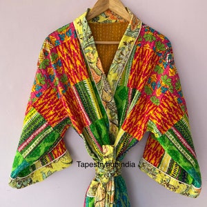 May include: A colorful patchwork robe with a floral print and a yellow trim. The robe has a tie belt and is made of cotton. The text "Tapestryhubindia" is visible on the robe.