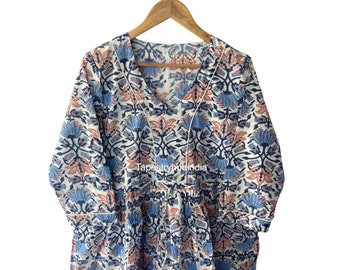 May include: A white cotton tunic with a blue and orange floral print. The tunic has a V-neckline and a tie at the waist. The text "Tapestryhouindia" is visible on the front of the tunic.