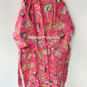 May include: A pink floral print robe with a white trim and a matching tie belt. The robe has a pocket on the left side and the text "Tapestryhubindia" is printed on the front.