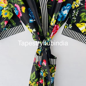 May include: Black floral cotton robe with a white and black striped trim. The robe is tied at the waist and has a floral pattern.