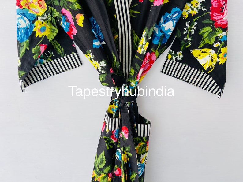 May include: Black floral cotton robe with a white and black striped trim. The robe is tied at the waist and has a floral pattern.