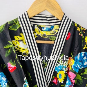 May include: Black floral print robe with a white and black striped trim around the collar. The robe has a V-neck and is made of cotton. The text "Tapestryhubindia" is visible on the robe.