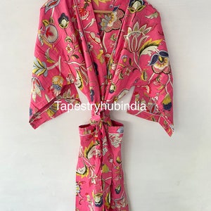 May include: A pink floral print cotton robe with a tie belt and long sleeves. The robe has a floral pattern with yellow, blue, and green accents. The text "Tapestryhubindia" is visible on the robe.
