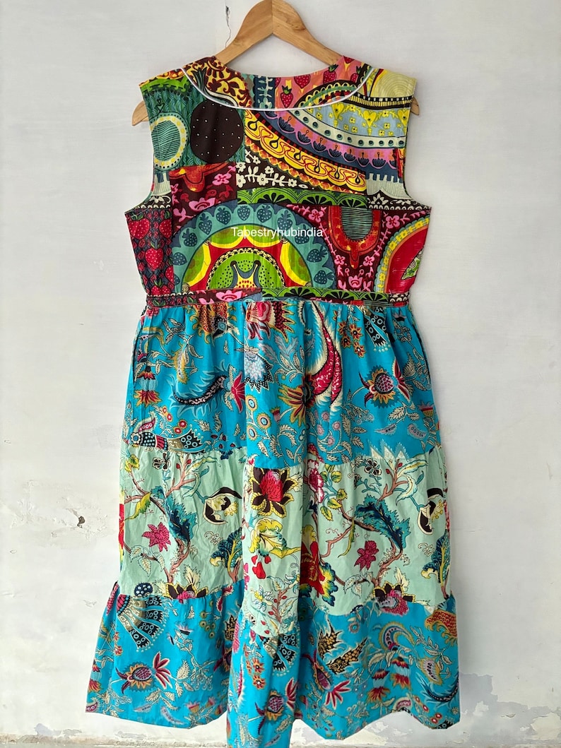 May include: A sleeveless, multi-coloured patchwork dress with a floral print. The dress has a gathered waist and a tiered skirt. The dress is made of cotton and is available in a variety of sizes.