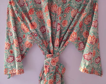 May include: A green and orange floral print robe with a white trim. The robe is tied at the waist with a sash.